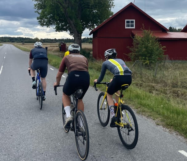 Tre personer cyklar längs en landsväg.